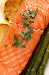 Photo of Tasty grilled salmon with asparagus and lemon, top view