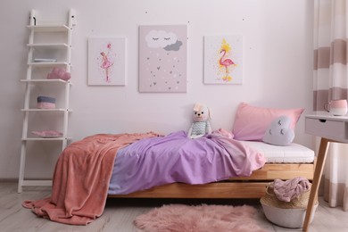 Photo of Comfortable bed with pink linens in children's room