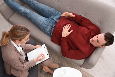 Psychotherapist working with young man in office, view from above