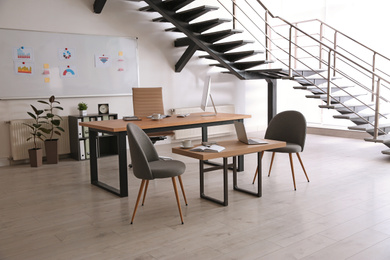 Stylish office interior with large wooden table