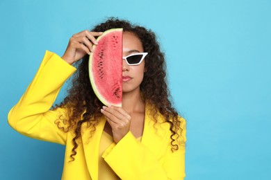 Photo of Beautiful young African American woman with watermelon on light blue background