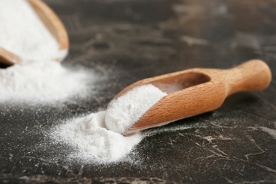 Photo of Scoops with baking soda on dark table