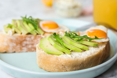 Photo of Plate of delicious avocado sandwiches on table, closeup