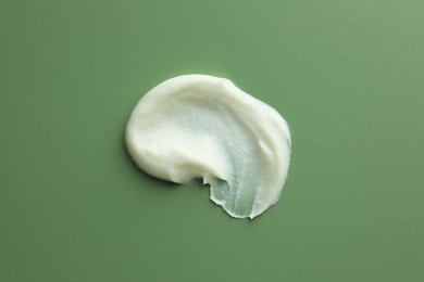 Sample of face scrub on green background, top view
