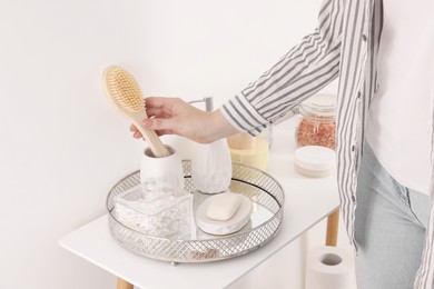 Photo of Bath accessories. Woman with brush indoors, closeup