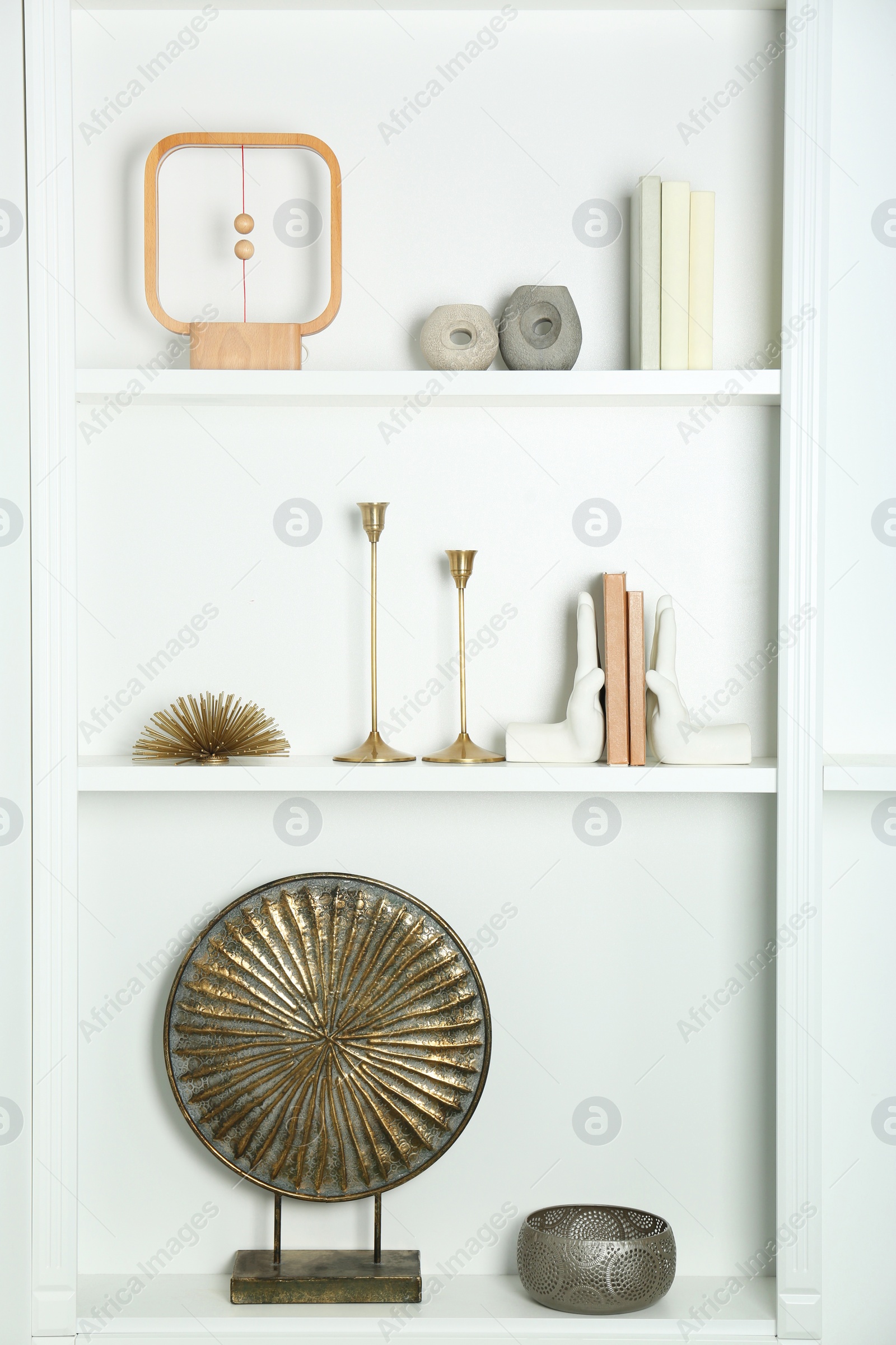 Photo of White shelves with books and different decor indoors. Interior design