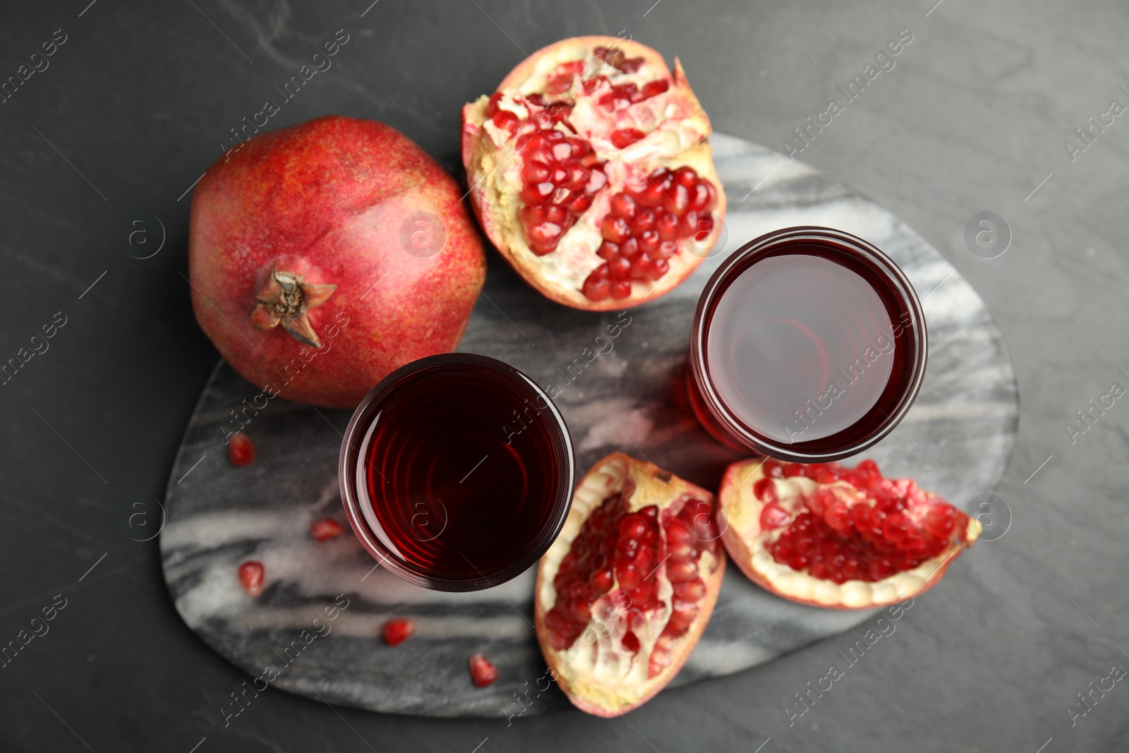 Photo of Pomegranate juice and fresh fruits on dark table, top view
