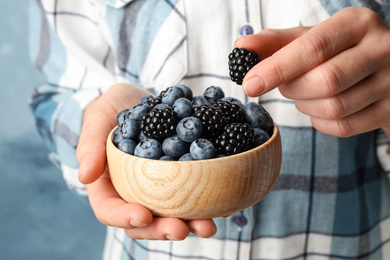 Photo of Woman with bowl of delicious summer berries, closeup