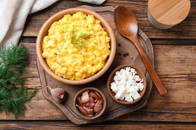 Tasty banosh served with brynza and pork cracklings on wooden table, flat lay. Traditional Ukrainian dish