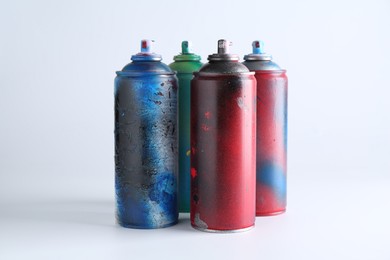 Many spray paint cans on white background