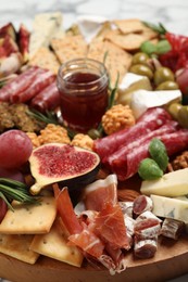 Photo of Different tasty appetizers on wooden board, closeup