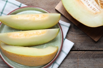 Pieces of delicious honeydew melon on wooden table, flat lay