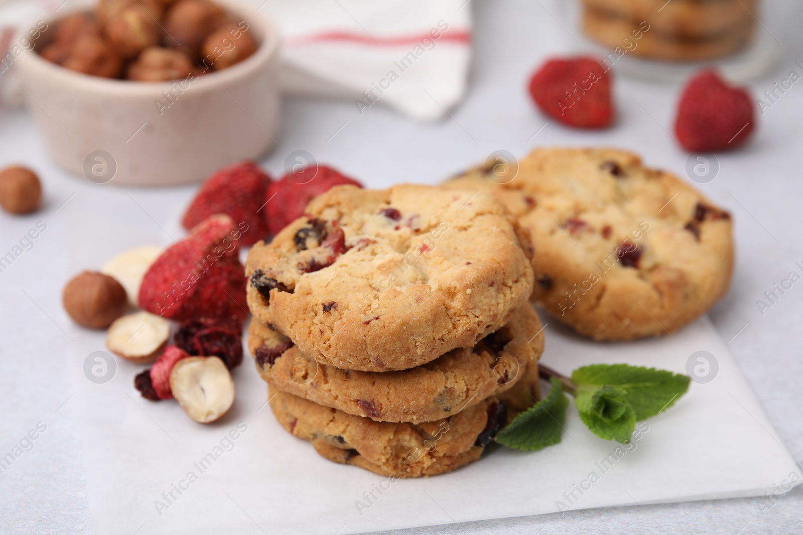Cookies with freeze dried fruits, nuts and mint on white table, closeup Photo of Cookies with freeze dried fruits, nuts and mint on white table, closeup