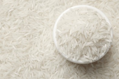 Photo of Raw basmati rice and bowl, top view. Space for text