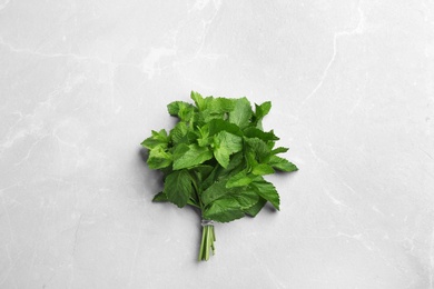 Photo of Bunch of fresh mint on grey marble  background, top view