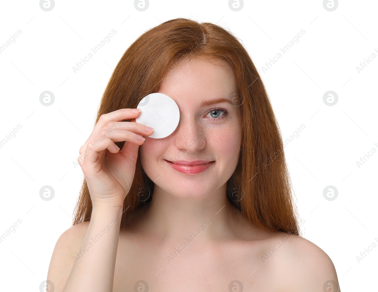 Photo of Beautiful woman with freckles covering eye with cotton pad on white background