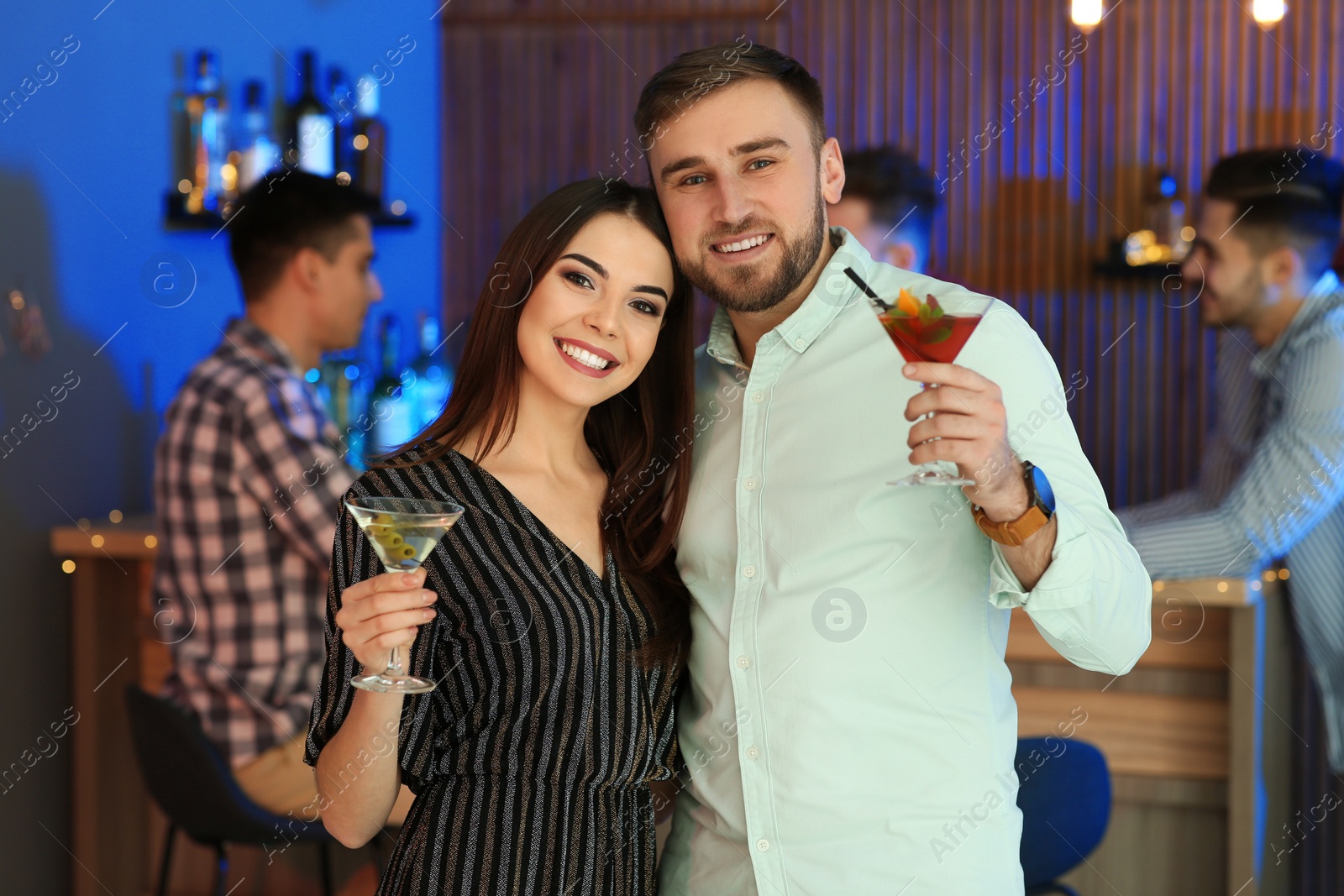 Photo of Young couple with martini cocktails at party