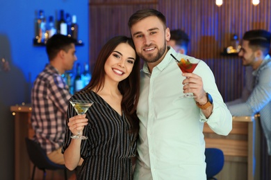 Photo of Young couple with martini cocktails at party