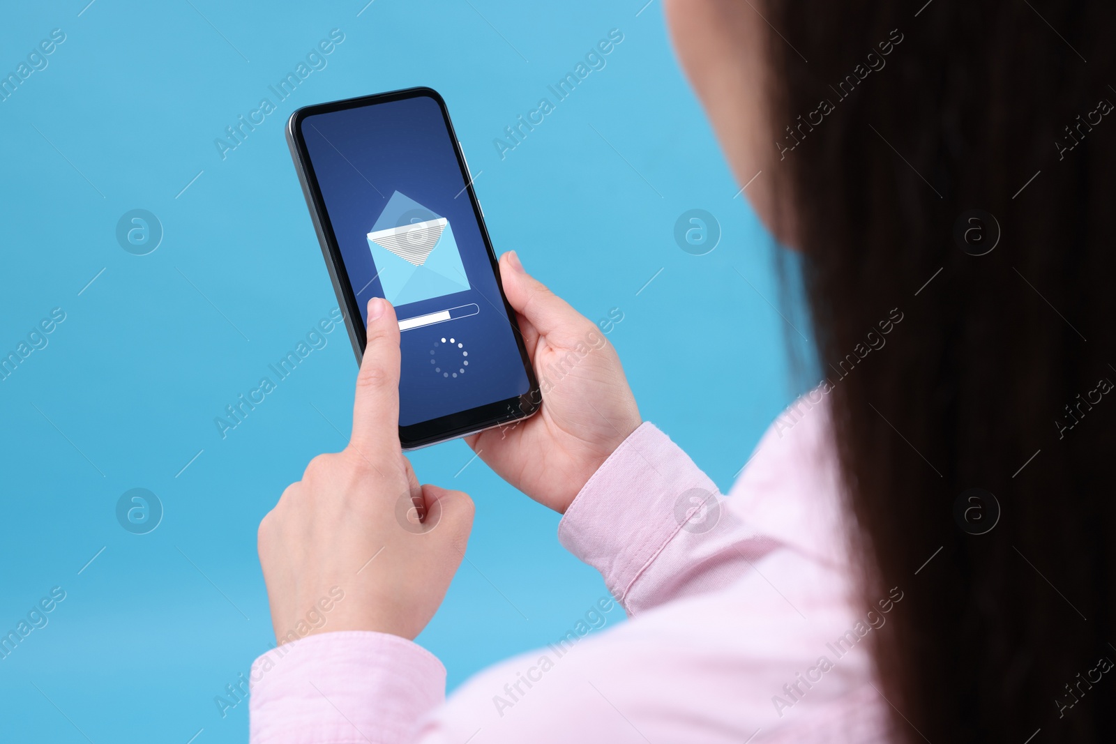 Image of Got new message. Woman using smartphone on light blue background, closeup