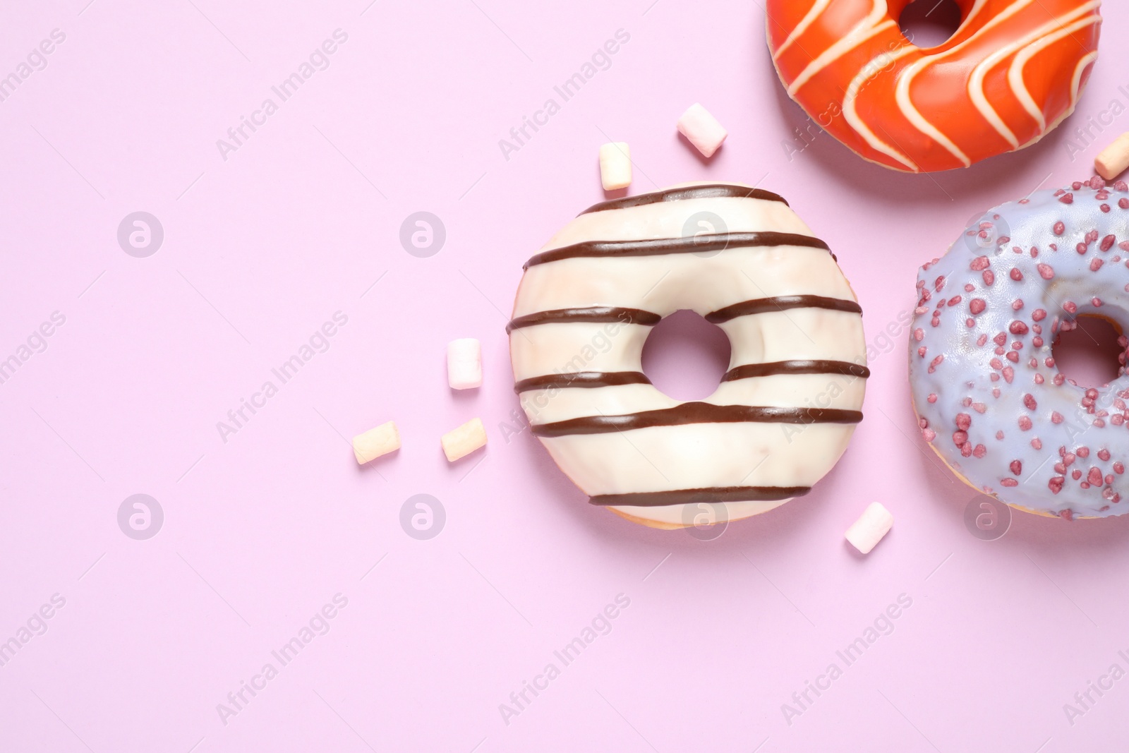 Photo of Delicious glazed donuts on lilac background, flat lay. Space for text