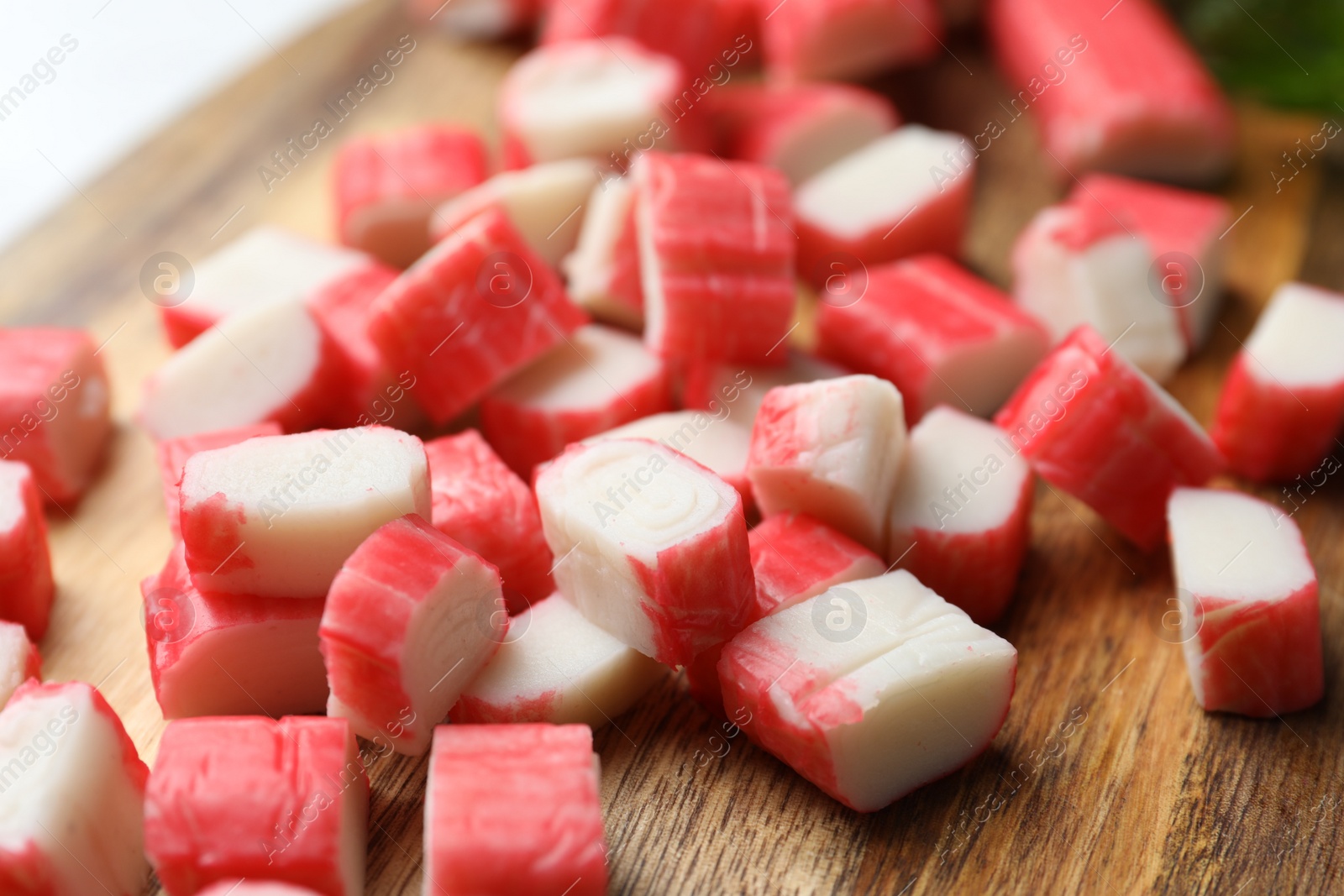 Photo of Delicious crab sticks on wooden board, closeup