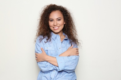 Young African-American woman with beautiful face on light background