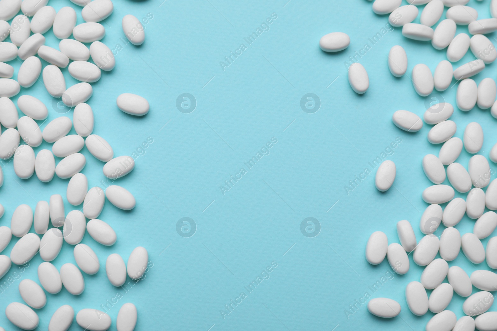 Photo of Many dragee candies on light blue background, flat lay. Space for text