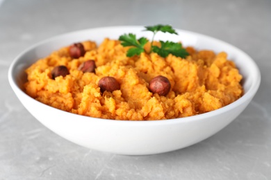 Bowl of tasty sweet potato puree on grey table