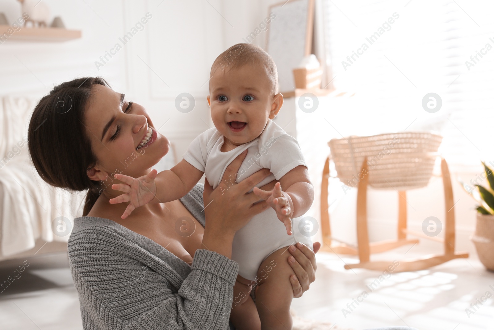 Photo of Happy young mother with her cute baby at home