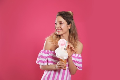 Photo of Portrait of young woman holding cotton candy dessert on pink background