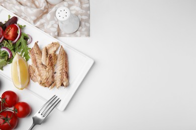 Delicious canned mackerel fillets served on white table, flat lay. Space for text