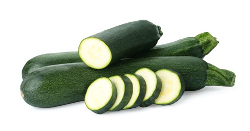 Photo of Cut and whole green ripe zucchini isolated on white