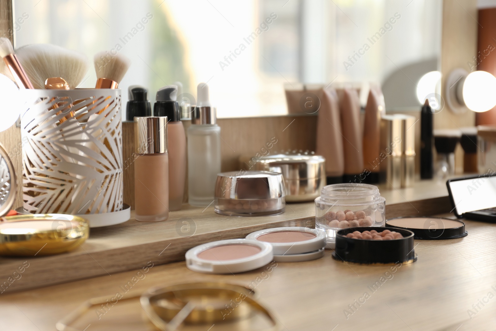 Photo of Many different cosmetic products on dressing table indoors