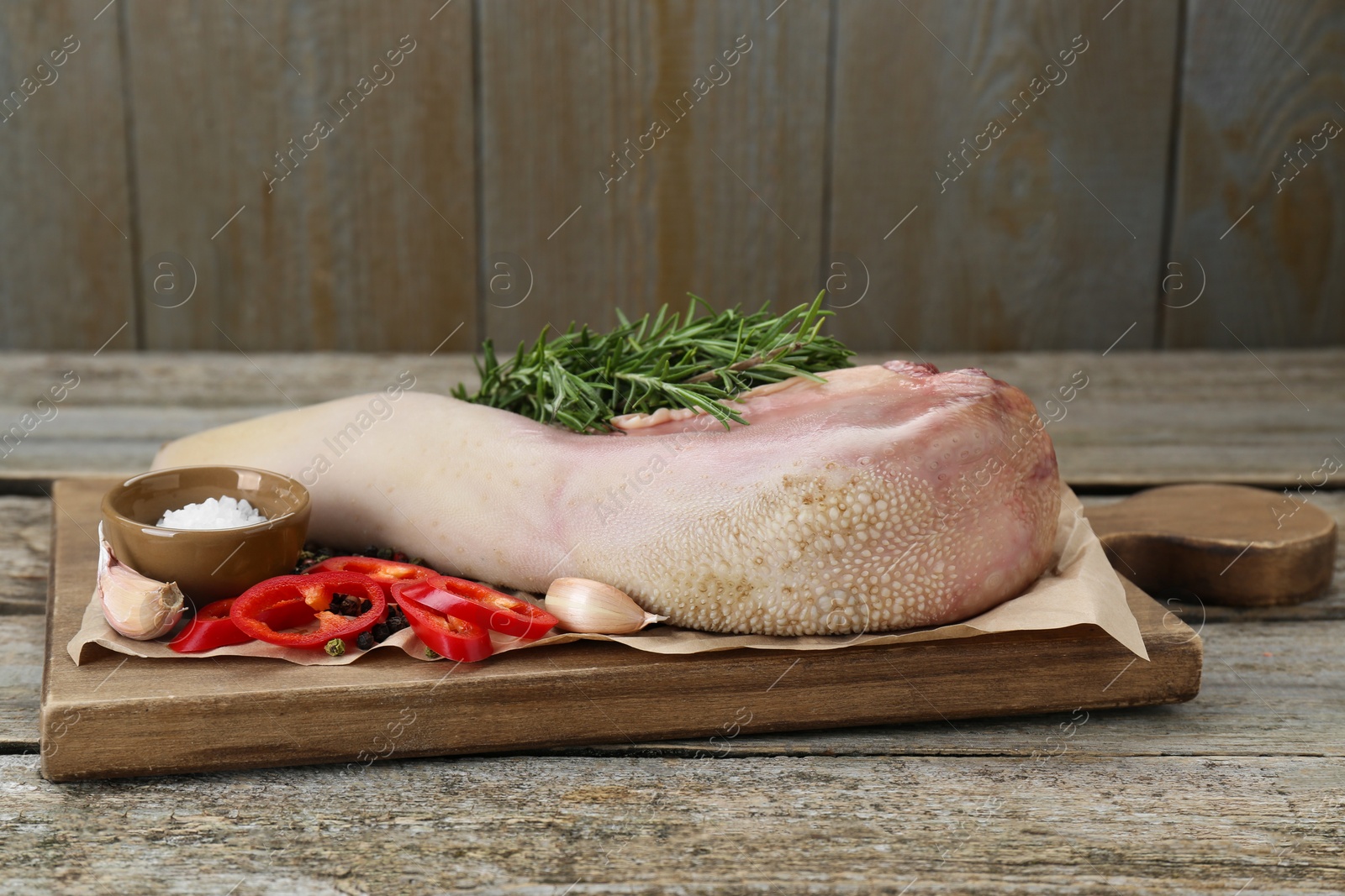 Photo of Board with raw beef tongue and products on wooden table