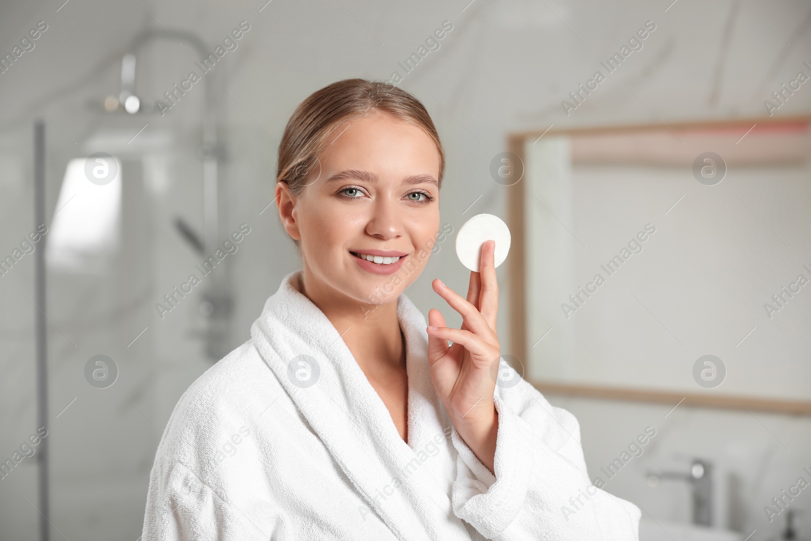 Photo of Beautiful young woman with cotton pad indoors