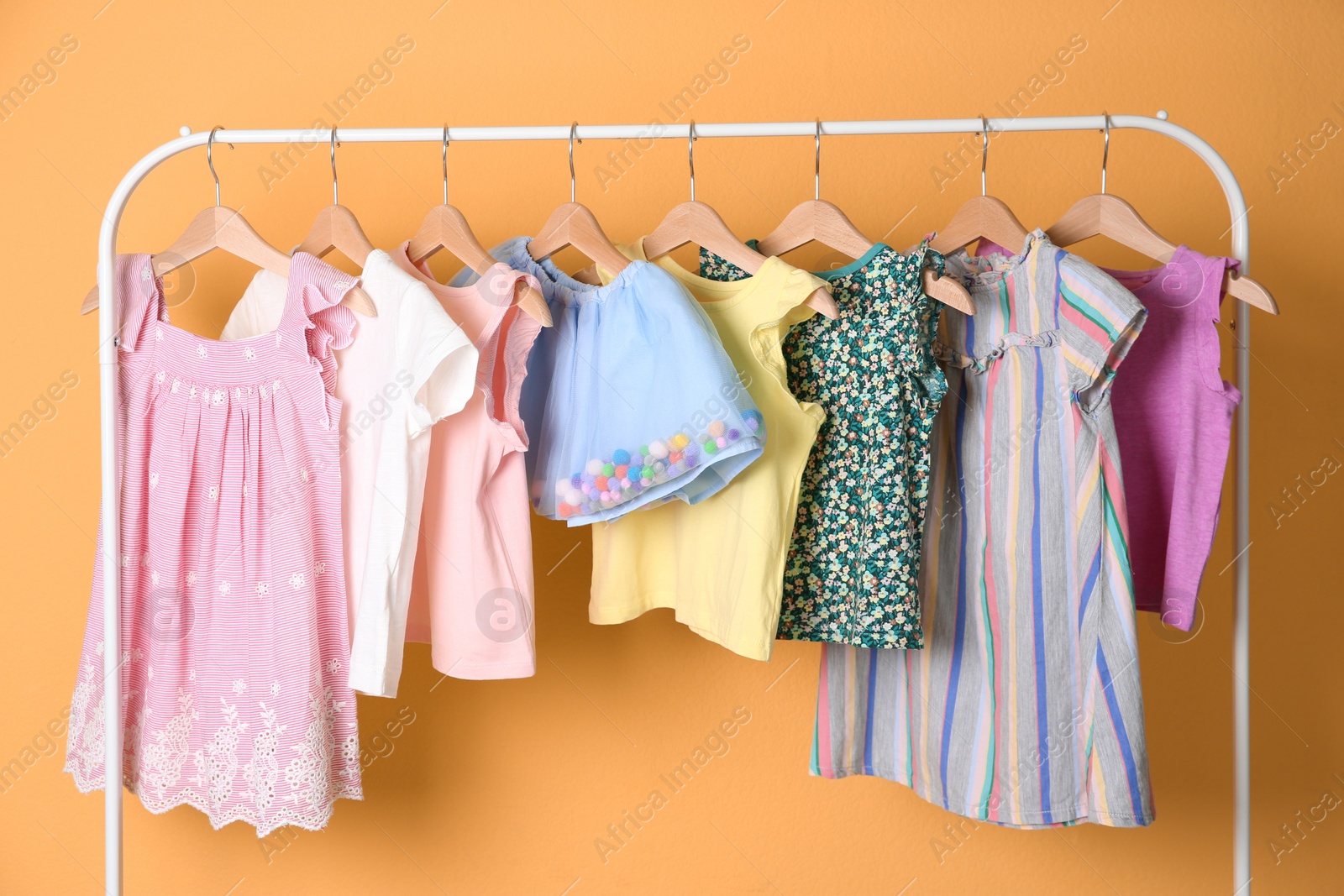 Photo of Rack with stylish child clothes on color background