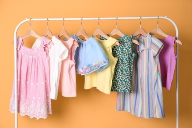 Photo of Rack with stylish child clothes on color background