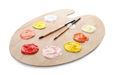 Palette with paints and brushes on white background