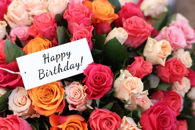 Image of Bouquet of beautiful roses with Happy Birthday card, closeup