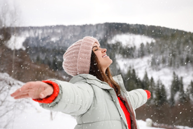 Photo of Happy woman against snowy mountains. Winter vacation