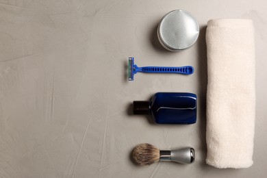 Photo of Set of men's shaving tools on light gray textured table, flat lay. Space for text