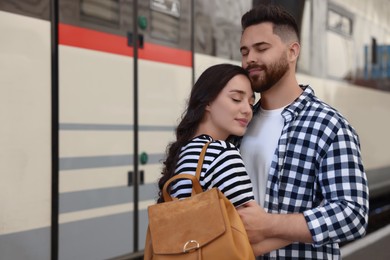 Long-distance relationship. Beautiful couple on platform of railway station