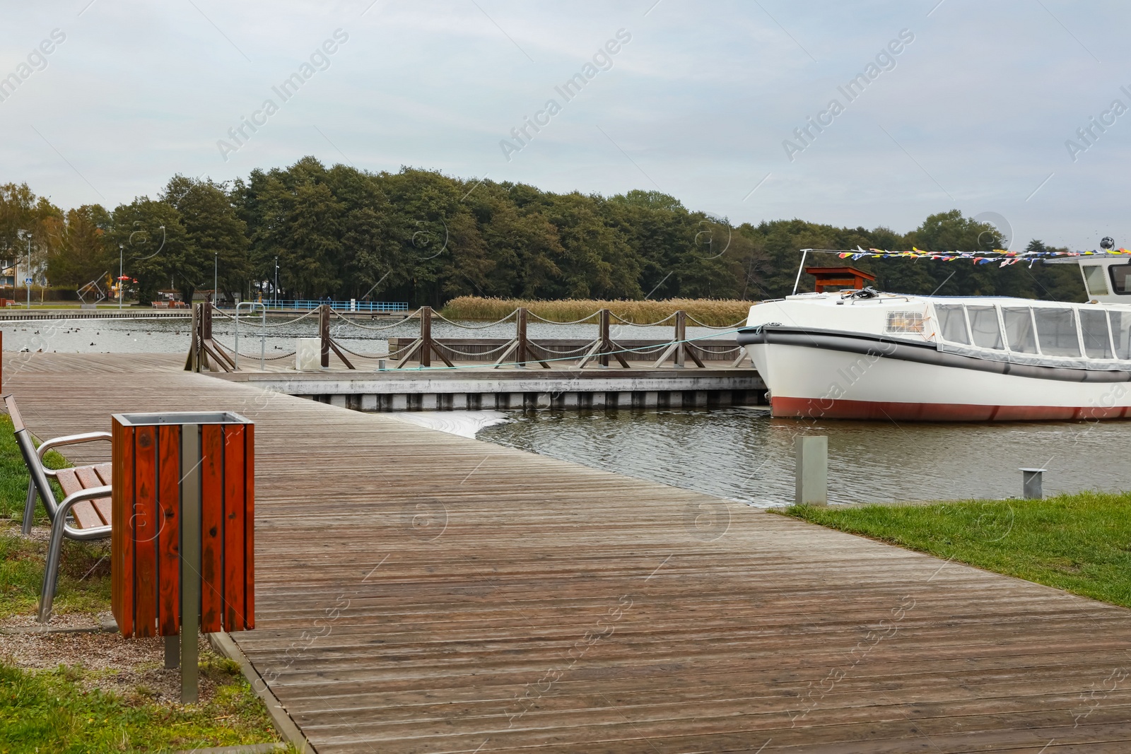 Photo of Recreation area with wooden bench for rent near pier. Real estate