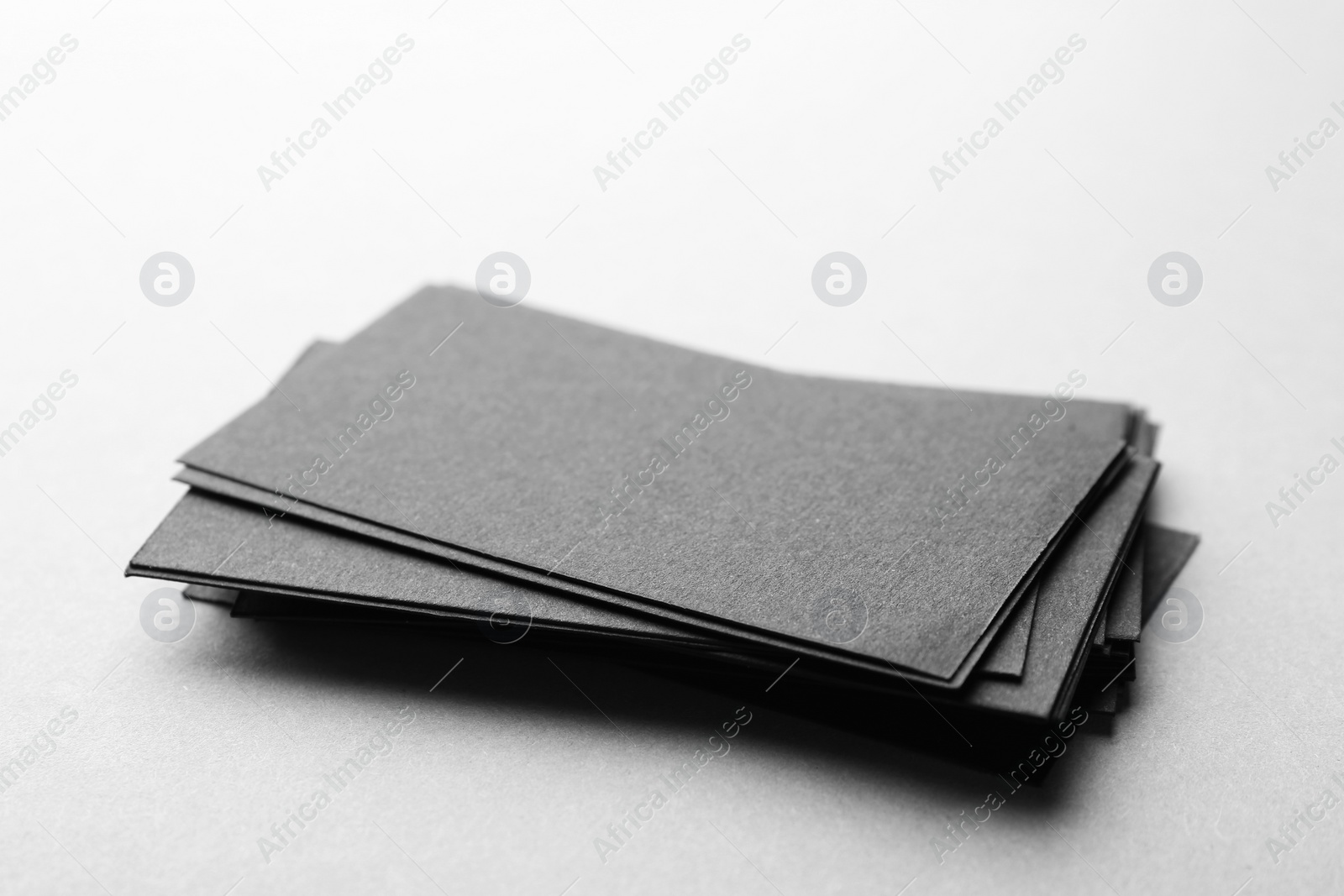 Photo of Blank black business cards on light background, closeup. Mockup for design