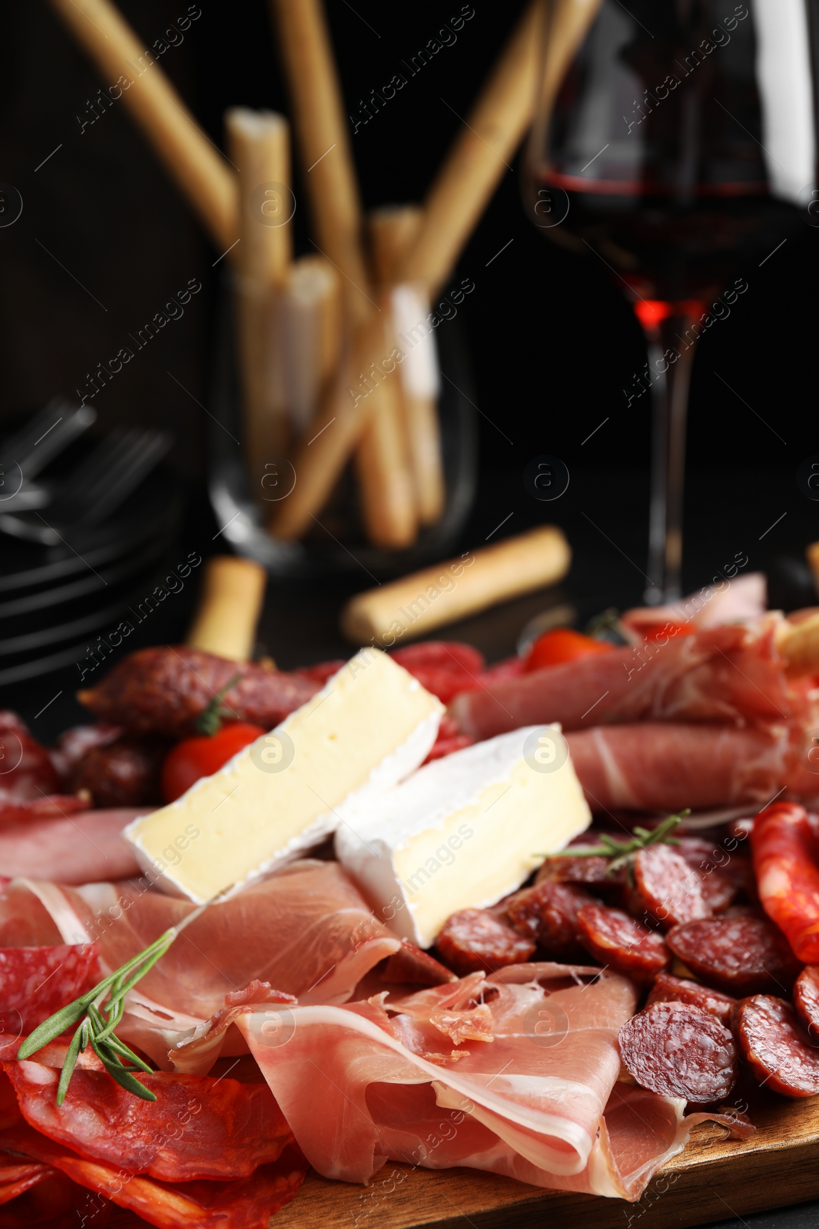 Photo of Tasty prosciutto with other delicacies served on table, closeup