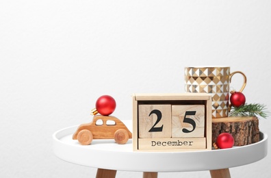 Wooden block calendar and festive decor on table. Christmas countdown