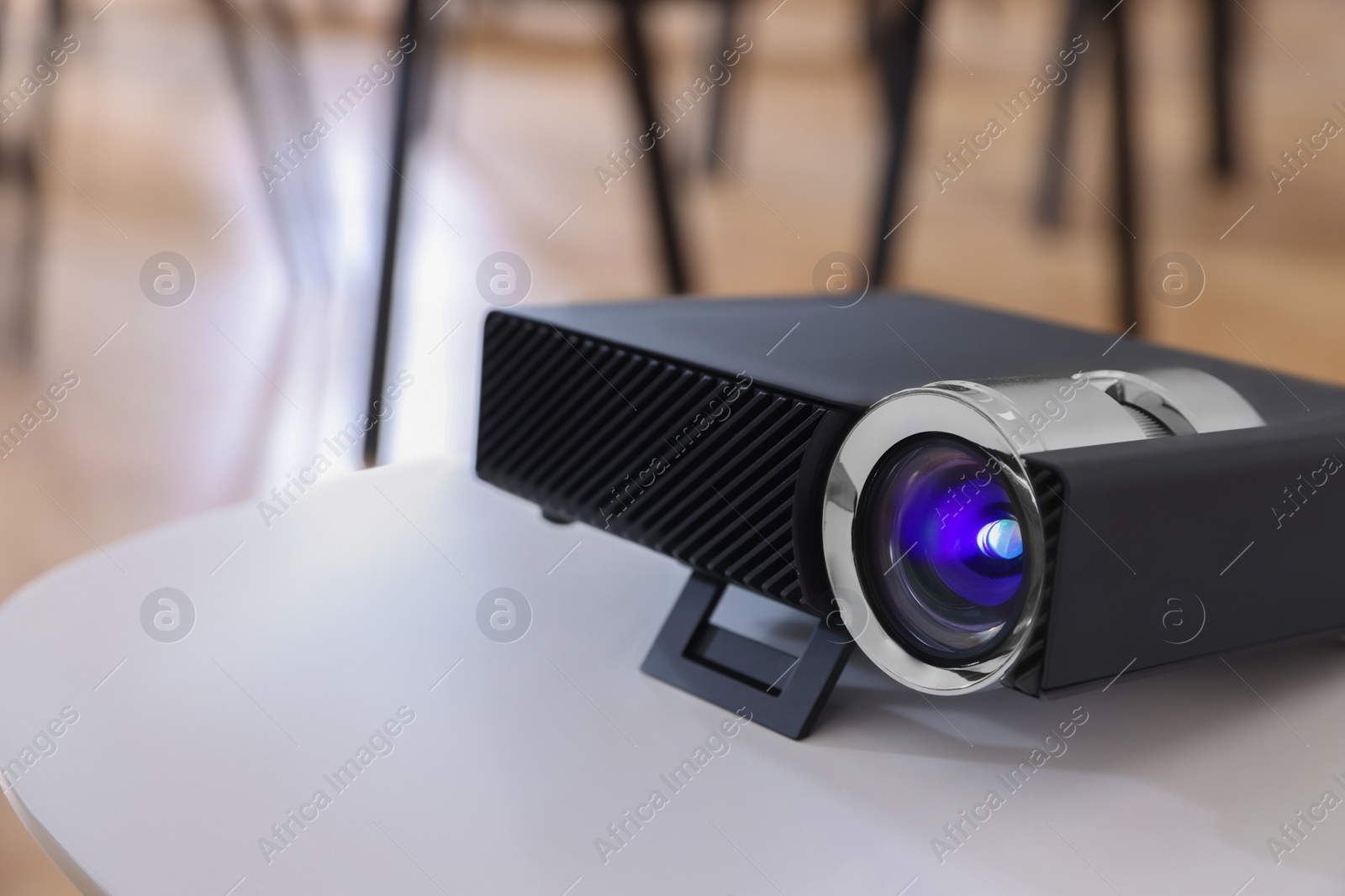 Photo of Modern video projector on table in conference room