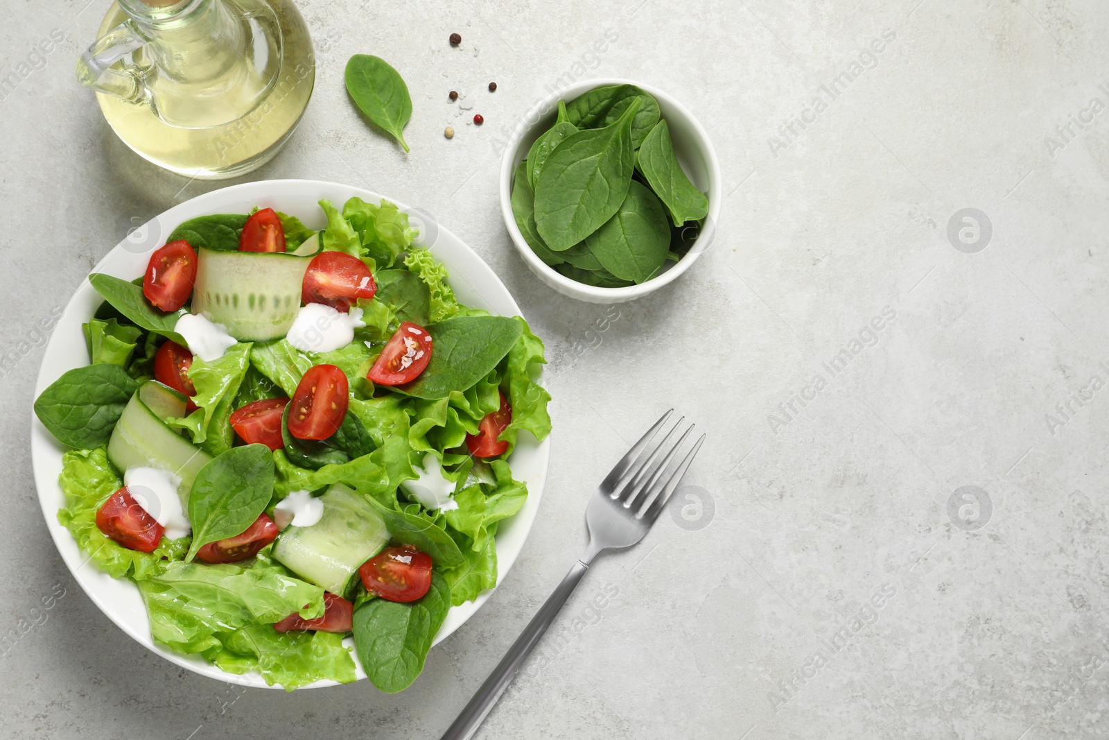 Photo of Delicious vegetable salad served on light grey table, flat lay. Space for text