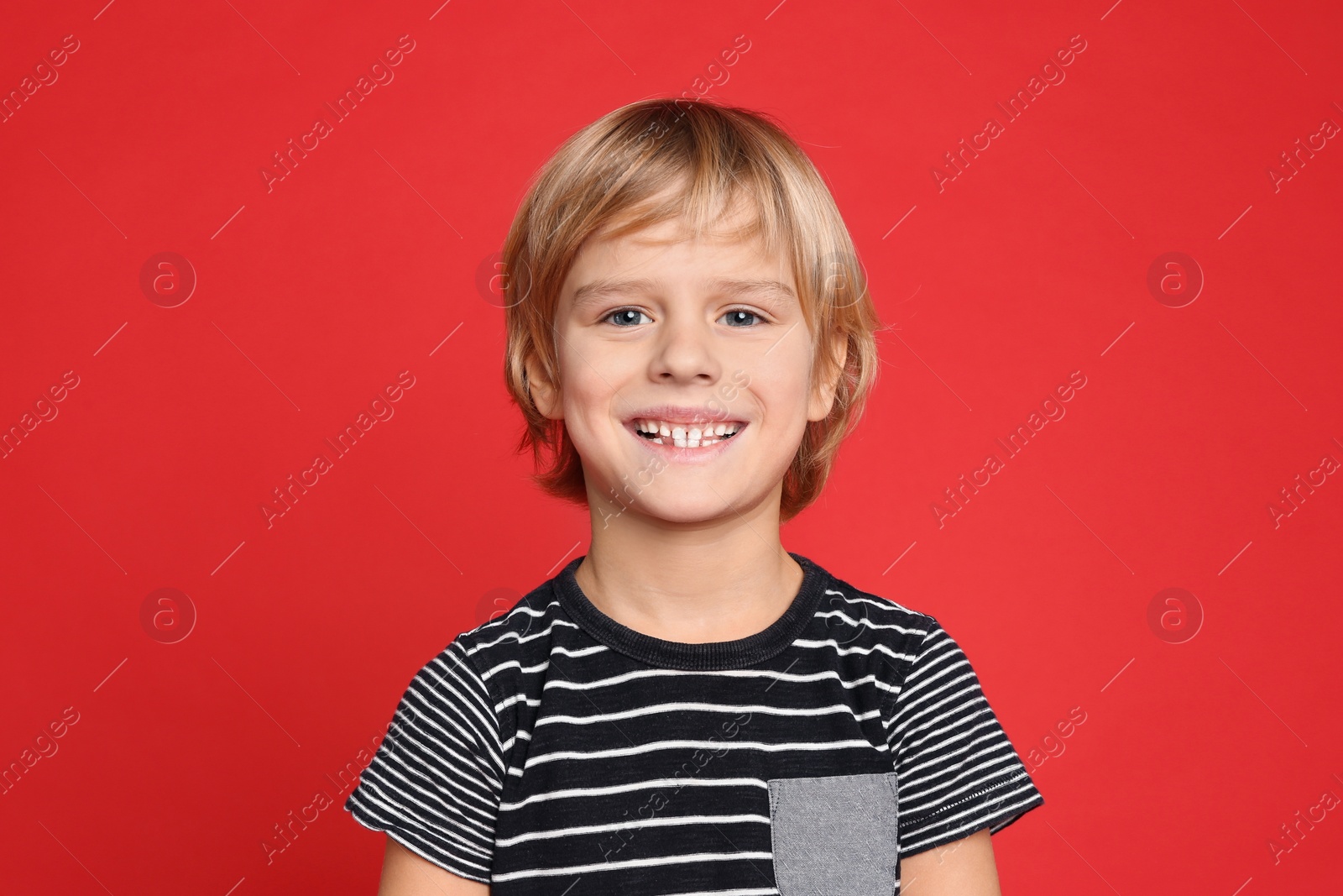 Photo of Portrait of happy little boy on red background