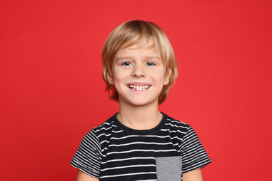 Portrait of happy little boy on red background